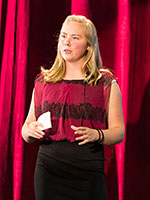 4-H'er in front of a red curtain.